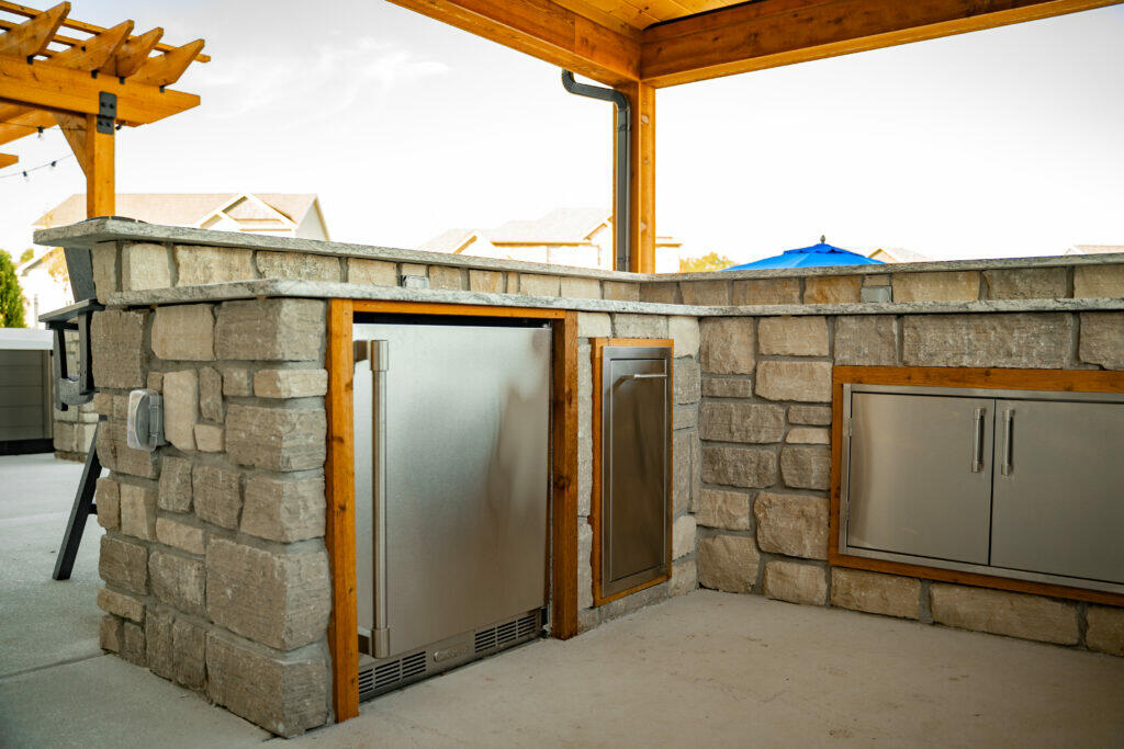 l-shaped outdoor kitchen with stone accents